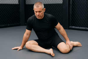 Man performing 90/90 hip rotation position to improve mobility for Brazilian Jiu-Jitsu training.
