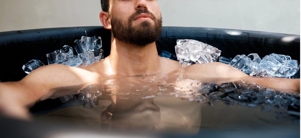 Man doing a cold plunge in an inflatable ice bath to support BJJ recovery and reduce inflammation.