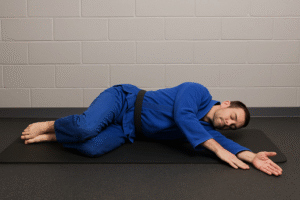 Open Book Thoracic Mobility Stretch for BJJ BJJ athlete doing open book thoracic rotation stretch to improve upper-back mobility
